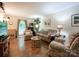 Cozy living room featuring hardwood floors, comfortable seating, and natural light streaming through the windows at 2214 Cannonade Ct, Matthews, NC 28105