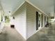 Inviting wraparound porch offering ample space for relaxation and outdoor enjoyment with wood floors and neutral colored siding at 2214 Cannonade Ct, Matthews, NC 28105