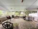 Enclosed porch featuring multiple seating areas, ceiling fan and view of the backyard at 2214 Cannonade Ct, Matthews, NC 28105