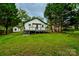 Exterior shot of the backyard showing the deck, a shed, and large green trees at 307 E 2Nd St, Lowell, NC 28098