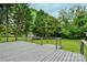 Well-maintained backyard deck overlooking the lawn, surrounded by lush green trees at 307 E 2Nd St, Lowell, NC 28098