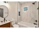 Modern bathroom with stylish vanity, marble tiles, and a bathtub shower combo at 307 E 2Nd St, Lowell, NC 28098