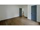 Spacious bedroom with hardwood floors and two doors, one gray, leading to other parts of the home at 307 E 2Nd St, Lowell, NC 28098