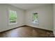 Inviting bedroom with hardwood floors and ample natural light from two windows overlooking the yard at 307 E 2Nd St, Lowell, NC 28098