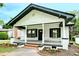 Charming single-story home featuring a welcoming front porch, black trim, and landscaped front yard at 307 E 2Nd St, Lowell, NC 28098