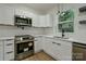 Stylish kitchen equipped with stainless steel appliances, white cabinetry, and modern fixtures at 307 E 2Nd St, Lowell, NC 28098