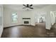 Bright living room featuring hardwood floors, a modern fireplace, and an open layout with kitchen views at 307 E 2Nd St, Lowell, NC 28098