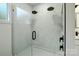 Sleek shower with frameless glass enclosure, marble tile, and dual shower heads at 307 E 2Nd St, Lowell, NC 28098