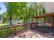 This home includes a large backyard with mature trees and a covered seating area on the wood deck at 319 Hatley Ne Cir, Concord, NC 28025