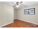 This bright bedroom features hardwood floors, neutral paint, and a ceiling fan and light fixture at 319 Hatley Ne Cir, Concord, NC 28025