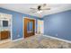This bedroom features blue walls, ceiling fan, wood closet, and a neutral toned rug at 319 Hatley Ne Cir, Concord, NC 28025