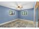 A blue bedroom features natural light, ceiling fan, and carpet at 319 Hatley Ne Cir, Concord, NC 28025