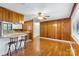 Open living and kitchen area with hardwood floors, breakfast bar seating, and wood-paneled walls at 319 Hatley Ne Cir, Concord, NC 28025