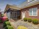Charming brick backyard with a screened porch and patio, surrounded by manicured landscaping and lush greenery at 324 Quinby Way, Rock Hill, SC 29732