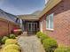 Charming brick backyard with a screened porch and patio, surrounded by manicured landscaping and lush greenery at 324 Quinby Way, Rock Hill, SC 29732