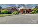 Brick building with elegant architectural details, lush landscaping, and a circular driveway at 324 Quinby Way, Rock Hill, SC 29732
