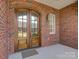 Elegant entryway featuring wood double doors with glass and a brick facade at 324 Quinby Way, Rock Hill, SC 29732