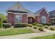 Charming brick home with manicured lawn, lush bushes, and a covered entryway at 324 Quinby Way, Rock Hill, SC 29732