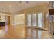 Open-concept living room featuring hardwood floors, stone fireplace, and access to the patio at 324 Quinby Way, Rock Hill, SC 29732