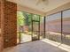 Relaxing screened porch with brick accents, overlooking a landscaped yard with mature plantings and a brick walkway at 324 Quinby Way, Rock Hill, SC 29732