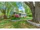 Quaint home with a manicured lawn, stone-lined flower beds, and mature trees providing ample shade at 400 Rhyne St, Stanley, NC 28164