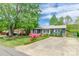 Inviting single-story home with a spacious driveway, mature trees, and colorful azalea bushes at 400 Rhyne St, Stanley, NC 28164