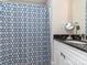 Bathroom with a white vanity cabinet with black countertop, vanity mirror and a shower with a blue patterned shower curtain at 4008 Widgeon Way, Waxhaw, NC 28173