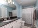 Bathroom with light blue walls, a vanity with black countertops and white cabinets, and a mirror at 4008 Widgeon Way, Waxhaw, NC 28173