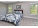 Bedroom featuring neutral tones, a comfortable bed with a patterned quilt, and large windows that let in plenty of natural light at 4008 Widgeon Way, Waxhaw, NC 28173