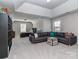 A bonus room features a comfortable sofa, a media center, and a bedroom area, ideal for relaxation and entertainment at 4008 Widgeon Way, Waxhaw, NC 28173