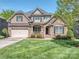 Inviting two-story brick home with a well-manicured lawn and charming curb appeal on a sunny day at 4008 Widgeon Way, Waxhaw, NC 28173