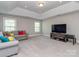 A spacious living room features a cozy gray sofa, a large TV, recessed lighting, and ample natural light at 4008 Widgeon Way, Waxhaw, NC 28173