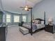 A primary bedroom featuring high ceilings, bay windows, a ceiling fan, and a four-poster bed at 4008 Widgeon Way, Waxhaw, NC 28173