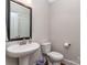 Bright powder room featuring a pedestal sink, and a toilet with hardwood-style flooring at 4008 Widgeon Way, Waxhaw, NC 28173