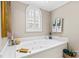 Corner jacuzzi tub with arched window, nautical decor, and neutral walls at 422 Wildwood Dr, Salisbury, NC 28146