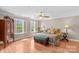 A well-lit main bedroom with an upholstered bench, hardwood floors, neutral walls, and bright windows at 422 Wildwood Dr, Salisbury, NC 28146