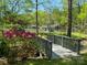 Charming backyard featuring a wooden bridge, vibrant azaleas, and a serene view of the lake at 531 Hattaway Dr, Mount Gilead, NC 27306