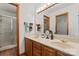 This bathroom features a double sink with wood cabinets, an entrance to a closet, and a glass door shower at 531 Hattaway Dr, Mount Gilead, NC 27306