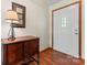 This entryway features wood flooring, a decorative cabinet, a decorative mirror, and a white front door at 531 Hattaway Dr, Mount Gilead, NC 27306