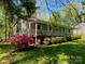 Side view of a charming home with a welcoming front porch, surrounded by beautiful greenery and flowering bushes at 531 Hattaway Dr, Mount Gilead, NC 27306