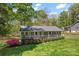 Scenic view of a charming home with a welcoming front porch, surrounded by lush greenery and trees at 531 Hattaway Dr, Mount Gilead, NC 27306
