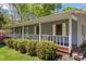 Inviting home showcasing a wide front porch, manicured bushes, and a glimpse of the serene neighborhood at 531 Hattaway Dr, Mount Gilead, NC 27306