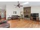 Inviting living room featuring a brick fireplace, skylight, hardwood floors, and a classic ceiling fan at 531 Hattaway Dr, Mount Gilead, NC 27306