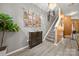 Wide hallway with luxury vinyl floors leads to a staircase and is decorated with a large plant and picture collage at 5310 Glenlea Walk Ln, Charlotte, NC 28216