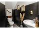 Chic powder room with black and gold walls, decorative mirrors, and a modern sink design at 5310 Glenlea Walk Ln, Charlotte, NC 28216