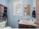 Bathroom featuring blue walls, a wooden cabinet and a decorative mirror at 7516 Pageland Hwy # 3, Monroe, NC 28112
