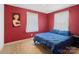 Red bedroom featuring a queen bed, carpet, and windows with white curtains at 7516 Pageland Hwy # 3, Monroe, NC 28112