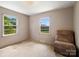 Bright bedroom featuring 2 windows and a recliner chair at 7516 Pageland Hwy # 3, Monroe, NC 28112