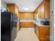 Functional kitchen with wood cabinets, tiled floor, and black appliances at 7516 Pageland Hwy # 3, Monroe, NC 28112