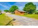 Single story brick home with a gravel driveway, mature trees and manicured green lawn at 862 Eastwood Dr, Rock Hill, SC 29730